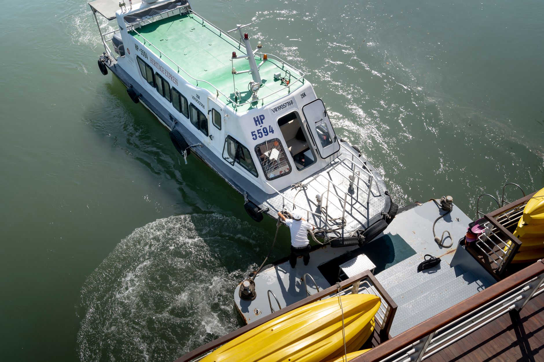 A ferry boat is docked at a pier with clear, calm waters on a sunny day.